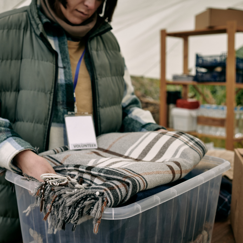 Person with bucket of blankets
